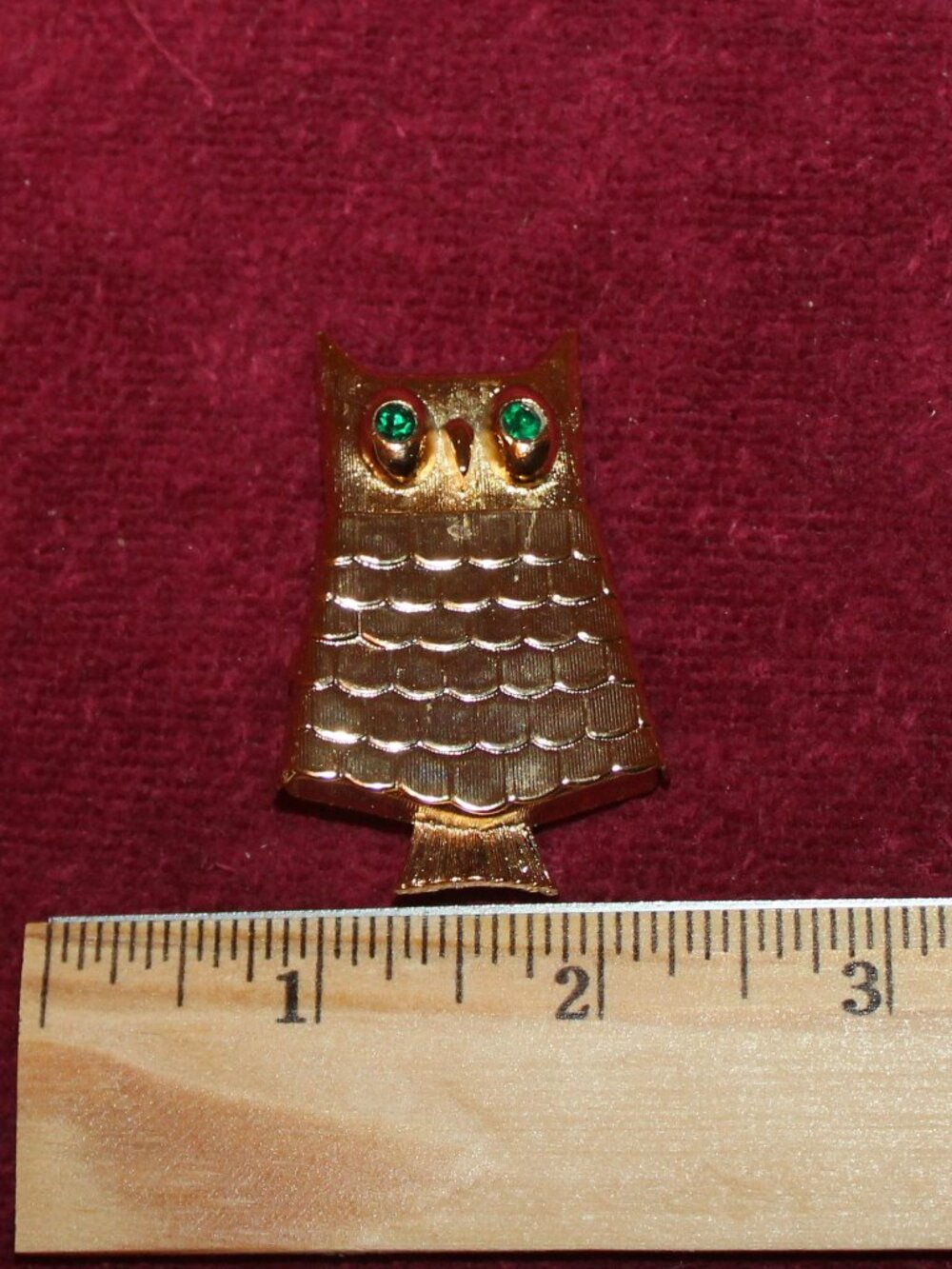 Vintage Avon gold-tone owl brooch with green rhinestone eyes, often featuring a